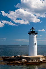 Puffy Cumulus Clouds Over New England Lighthouse Tower